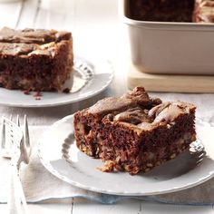 two pieces of brownie on plates with fork and cake pan in the back ground