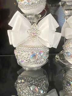 three glass vases with bows and jewels on them