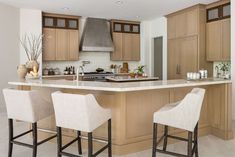 a kitchen with two bar stools next to an island