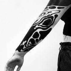 a man with a black and white tattoo on his arm is holding out his hand