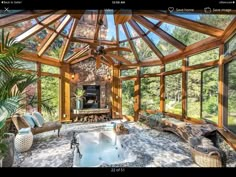 an indoor hot tub in the middle of a room with wood beams and glass walls