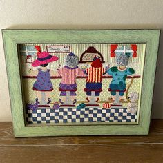 a picture frame with some little kids in the kitchen and one is wearing a hat