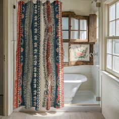 a bathroom with a shower curtain, tub and window in it's center area