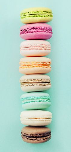 a stack of macaroons sitting next to each other on top of a blue surface