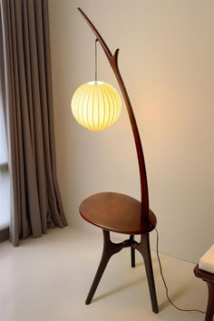 a lamp that is sitting on top of a table next to a chair and window