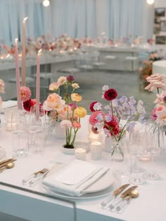 the table is set with flowers and candles for an elegant wedding reception or special event