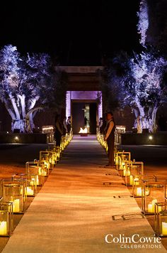 candles are lined up on the walkway leading to an entrance