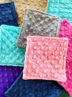 there are many different colored crocheted squares on the table