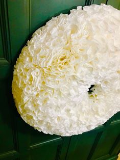 a large white doughnut sitting on top of a green door