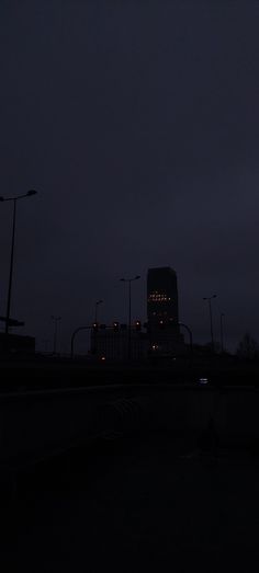 the sky is dark and there are street lights in front of some buildings at night