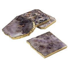 two pieces of gold and purple stone on white background