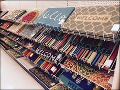 a store shelf filled with lots of different colored fabric and wall hangings on it's sides