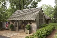 a small wooden shed with an american flag on the roof