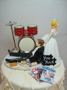 a wedding cake topper with a couple on it and music instruments in the background