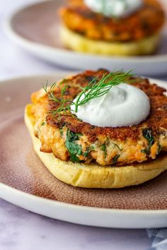 crab cakes with sour cream and herbs on top