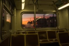 the inside of a train car with empty seats and windows at sunset or sunrise time