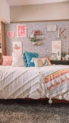 a bed sitting in a bedroom next to a wall with pictures on the walls above it