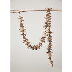 two necklaces made out of driftwood hanging from a branch