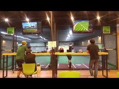 people are playing video games in an indoor tennis court while others watch from the stands