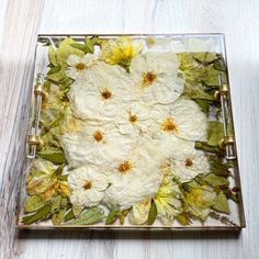 a glass plate with flowers and leaves on it