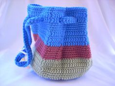 a crocheted purse is shown on a white background with a blue handle and handles