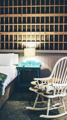 a rocking chair next to a bed in a room