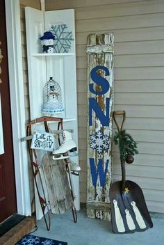 a wooden sign sitting on the side of a building next to a snowboard and sled