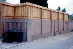 a wooden fence next to a brick wall