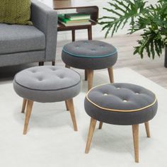 three stools with footstools in front of a couch and coffee table on a rug