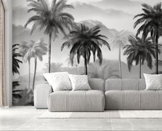 a couch sitting in front of a palm tree wallpapered living room with black and white walls