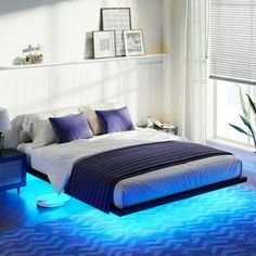 a bed room with a neatly made bed and blue lights on the floor next to a window