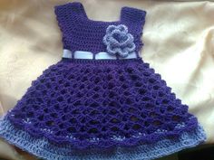 a crocheted dress with a flower on it