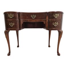 an antique wooden desk with two drawers on one side and gold accents on the other