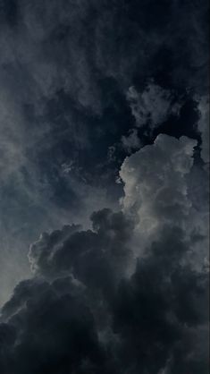 an airplane is flying through the cloudy sky