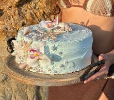 a woman holding a cake with flowers on it