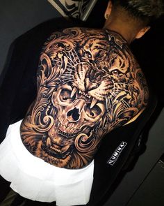 a man with a tattoo on his back is wearing a black and white tiger head