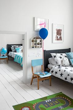 a child's bedroom with white walls and wooden floors, decorated in blue and green