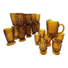 a collection of yellow glass cups and pitchers