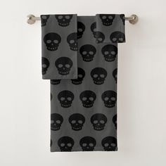 two towels with skulls on them hanging from a towel rack in front of a white wall