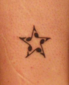 a small star tattoo on the back of a woman's left arm, with three smaller stars in the middle