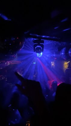 people are dancing in a club with bright lights