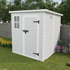 a large white shed sitting on top of a lush green field