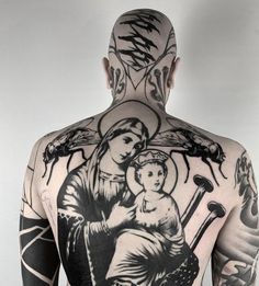 the back of a man's body with tattoos on it, including an image of a woman holding a baby