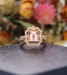 an engagement ring with a pink diamond surrounded by flowers