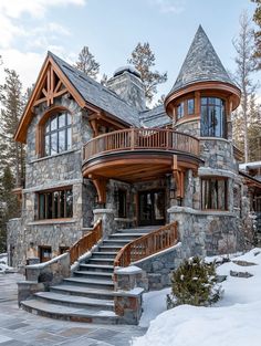 a stone and wood house in the snow with stairs leading up to it's second story