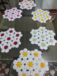 four crocheted flowers are arranged on the floor