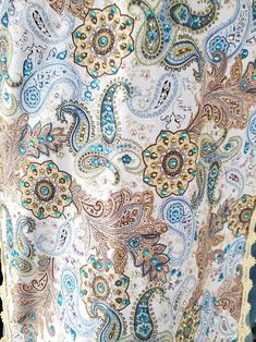 an image of a woman wearing a dress with paisley print on it and gold trimmings