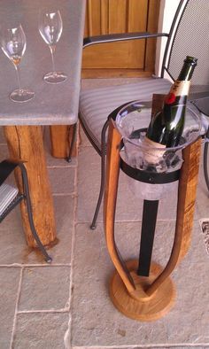 a wine bottle is sitting in a glass holder on a table with two chairs around it