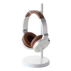 a pair of headphones sitting on top of a white stand in front of a white background