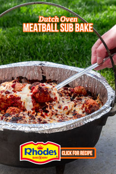 a person holding a spatula over meatball sub bake